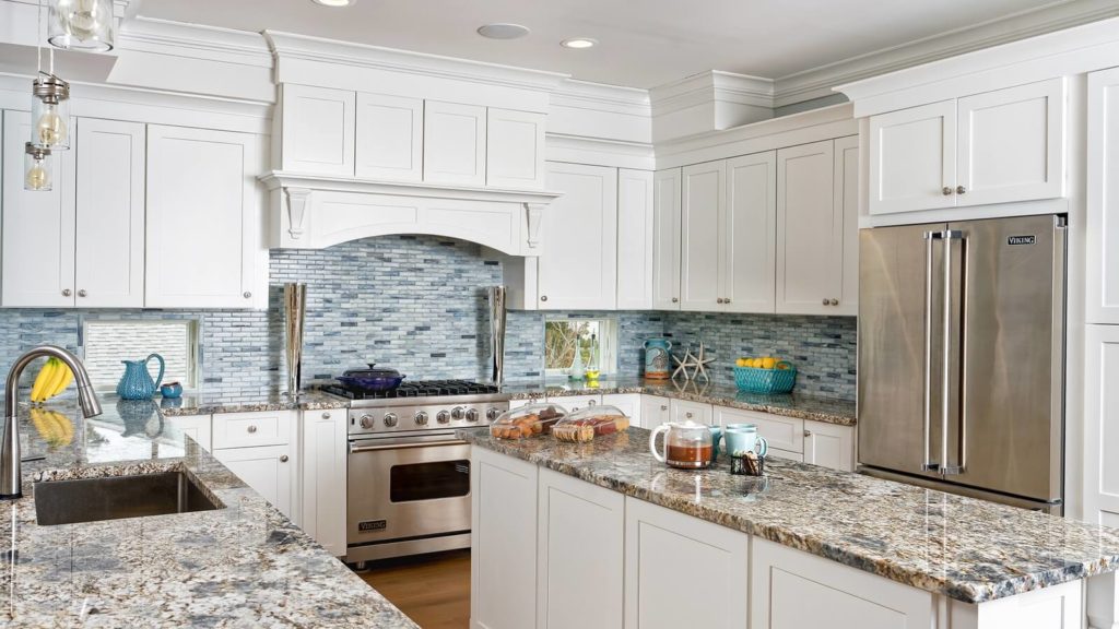 a white kitchen cabinet with range hood and architectural accents